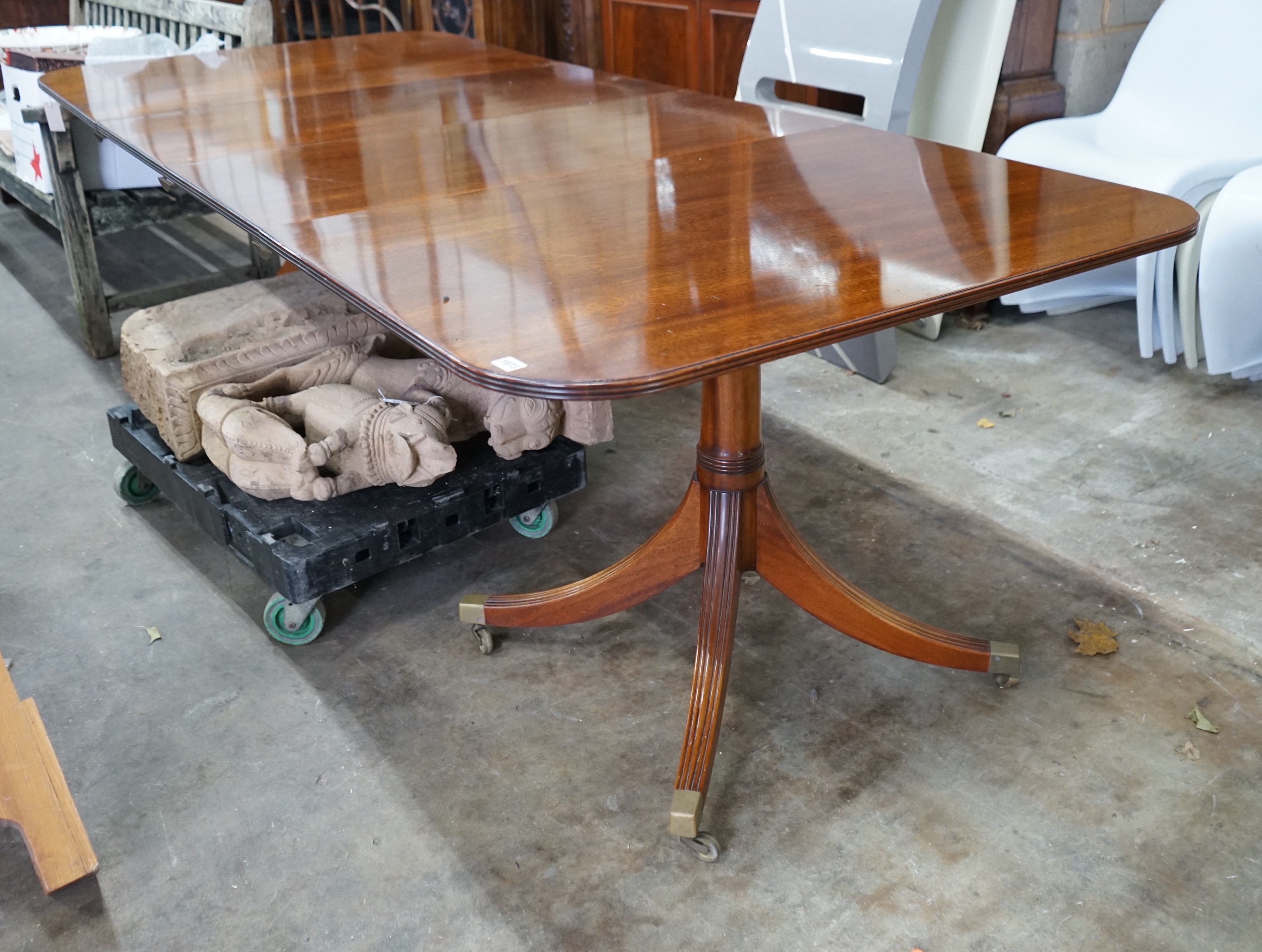 A reproduction Tillman style mahogany twin pillar extending dining table 246cms extended, two spare leaves, width 107cms, height 72cms.
